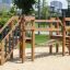 Parco giochi in legno Bridge su superficie sabbiosa con scale da arrampicata e ponte.