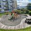 Attrezzatura da gioco Kiosk con scivolo e altalene in un'area residenziale.