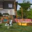 Sun Shade Triangle 3x3x3 Nature (Robinia) in un'area giochi con un'altalena a molla, una sabbiera e pla