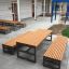Set di mobili da esterno Kyoto: tavoli e panche in legno con telai in metallo in una moderna area patio.