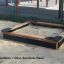 Sabbiere in legno con Dino sandbox base in un parco giochi all'aperto.