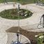 Parco fitness all'aperto con varie attrezzature per esercizi e vegetazione.