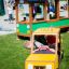 Bambini che giocano in un veicolo da parco giochi a tema Taxi giallo.