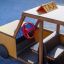 Taxi in legno da parco giochi con volante rosso.