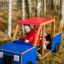 Bambini che giocano in un'attrezzatura da parco giochi in legno a forma di camion.