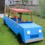 Gioco blu Truck con tetto rosso e struttura in legno in un cortile.