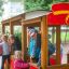 Bambini che giocano su un'auto dei vigili del fuoco in legno nel parco giochi.