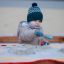 Bambino che gioca con una pala blu nel All accessible sandbox riempito di sabbia