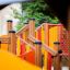Attrezzatura da parco giochi in legno Gamma per bambini, con scivoli colorati e strutture da arrampicata.