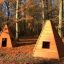 Due Wigwam wooden house in una radura di un bosco autunnale.