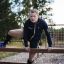 Uomo che usa Double Jump Bars attrezzatura da area giochi all'aperto.