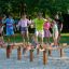 Attrezzature da gioco con travi di equilibrio in legno Hip Hop con bambini che giocano sulla sabbia.