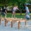 Attrezzature da gioco con travi di equilibrio in legno Hip Hop con bambini che giocano.