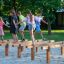 Bambini che giocano ed equilibrano sulle attrezzature da gioco in legno Hip Hop all'aperto.