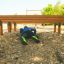 Persona che striscia sotto un percorso a ostacoli in legno Hip Hop in un parco giochi.