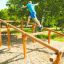 Persona che usa Climb Obstacle wooden ladder in un parco all'aperto.