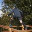 Uomo che scala il Climb Obstacle wooden ladder in un parco all'aperto.
