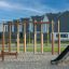 Struttura da arrampicata in legno Horizontal Ladder Large su un parco giochi con superficie di sabbia e residenziale ho