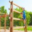 Ragazzo che si arrampica su Step And Climb wooden ladder in un'area giochi.