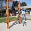 Bambini che giocano su Step And Climb wooden ladder in un parco giochi.