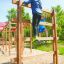 Bambini che si arrampicano su Step And Climb wooden ladder in un'area giochi.