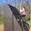 Donna che si arrampica sul Climbing Ramp steel structure in un parco giochi all'aperto.