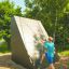 Ragazzo che si arrampica su Climbing Ramp steel structure in un parco giochi all'aperto.