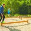 Adulti e bambini in equilibrio sull'attrezzatura fitness all'aperto Balance.