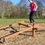 Donna in equilibrio sull'attrezzatura da gioco all'aperto Easy Balancer.