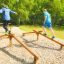 Due persone in equilibrio sull'attrezzatura fitness all'aperto Easy Balancer in un parco.