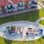 Struttura da parco giochi che ricorda una nave con scivolo ed elementi di arrampicata in una zona residenziale.