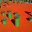 Verde Jumping pegs (5 pcs.) su un parco giochi arancione.