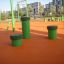 Pali elastici verdi (5 pz.) in un parco giochi all'aperto con pavimentazione in gomma arancione.