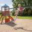 Due bambini che giocano su un Double Swing with Tower playhouse with slide in una giornata di sole.