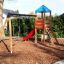 Double Swing with Tower playhouse with slide in un parco giochi in giardino