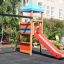 Double Swing with Tower playhouse with slide in un contesto di giardino