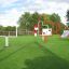 Allestimento all'aperto di attrezzature da parco giochi Aim Practice II con telai rossi e bianchi sull'erba verde.