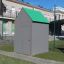 Riparo per area giochi con tetto verde e pareti grigie.
