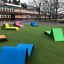 Lounge chair da esterno colorato posizionato su un prato verde davanti a un edificio.