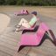 Uomo seduto su un Lounge chair rosa all'aperto in una giornata di sole.