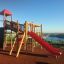 Twister castle with slide in un parco giochi con vista mare sullo sfondo.