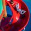 Bambino che scivola su Twister castle with slide.