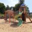 Twister castle with slide su un parco giochi sabbioso.