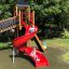 Bambini che giocano su Twister castle with slide in un parco.