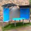 Shelter with table per sedute all'aperto con pannelli blu.