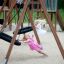 Due ragazze che giocano su Double Swing (BNS 90cm) nel parco giochi.