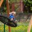 Bambino che si dondola su un Double Swing (BNS 90cm) in un parco giochi.