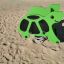 Giostra a molla verde Turtle rocking su superficie sabbiosa.