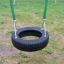 Double Swing con sedile in gomma nera e sfondo erboso.