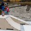 Bambino che esegue un trick con lo skateboard su Jump-Ramp mentre un altro bambino guarda.